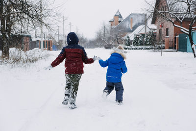 Outdoor winter activities for kids. kids playing in the suburbs, winter backyard gathering. boys