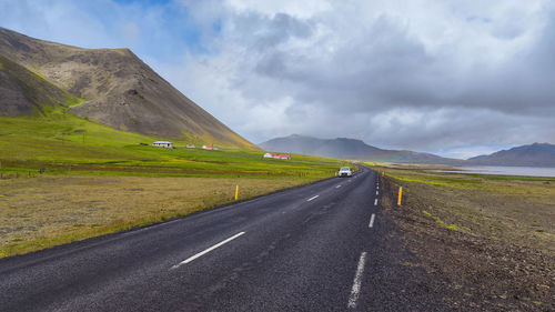 Road amidst field against sky