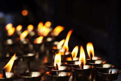 Close-up of burning diyas in temple