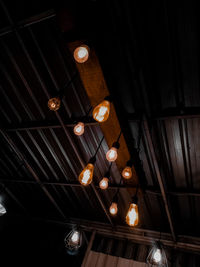 Low angle view of illuminated pendant lights hanging from ceiling