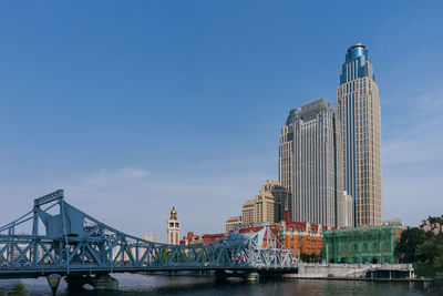 Bridge over river against buildings in city