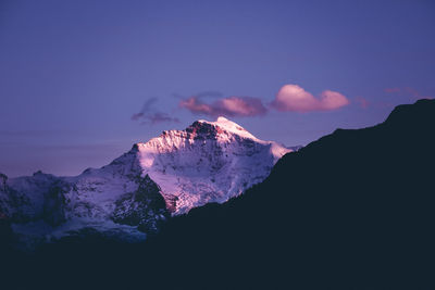 Scenic view of snowcapped mountains against sky at sunset