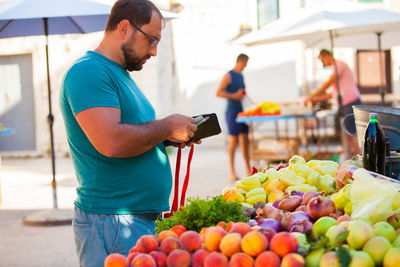 Full length of man holding fruits at market