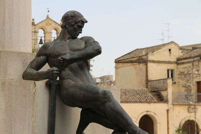 Low angle view of statue against historic building