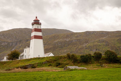 Lighthouse on field against sky, alnes - norway