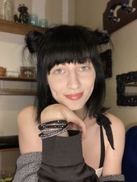 Close-up portrait of young woman sitting at home