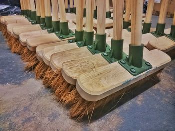 Close-up of wooden brooms at factory