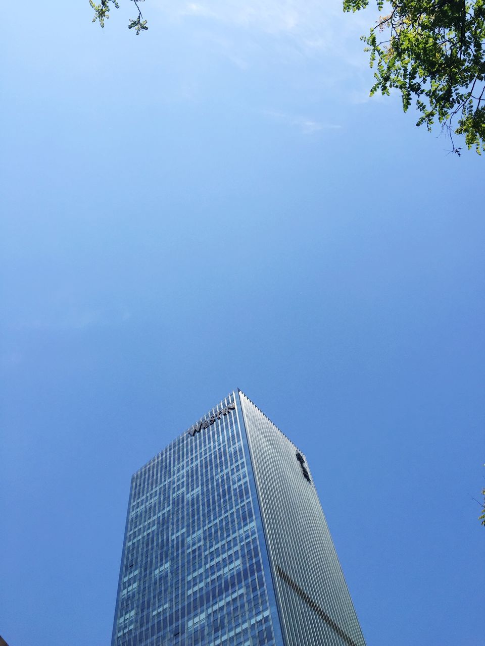 low angle view, building exterior, architecture, built structure, modern, office building, skyscraper, tall - high, city, sky, tower, building, blue, clear sky, day, outdoors, copy space, tall, no people, directly below