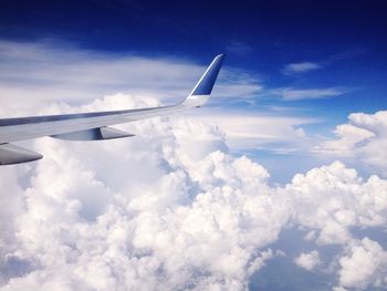 Cropped image of airplane flying over clouds