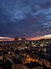 Aerial view of illuminated cityscape against sky at night