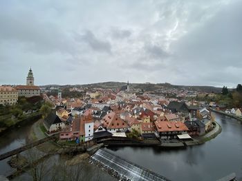 High angle view of townscape by river against sky