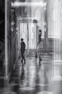 Blurred motion of man walking in illuminated corridor