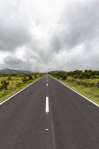 Empty road along countryside landscape