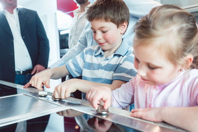 High angle view of siblings checking stove in store