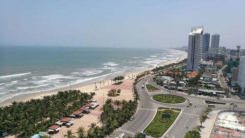 High angle view of city by sea against sky