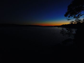 Scenic view of lake against clear sky at sunset