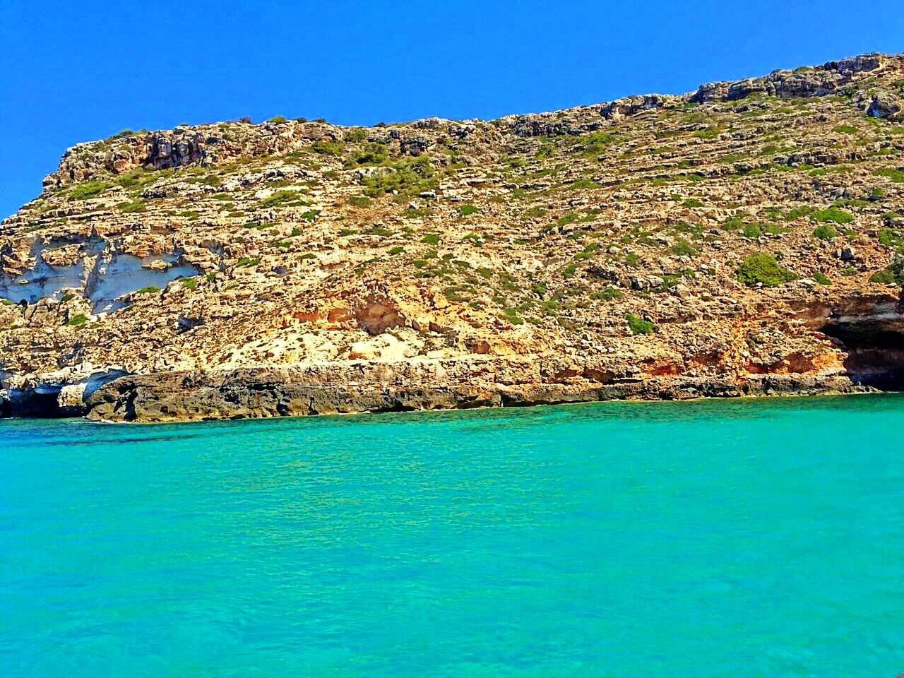 blue, clear sky, water, tranquil scene, waterfront, scenics, tranquility, sea, rock - object, turquoise colored, rock formation, beauty in nature, nature, mountain, cliff, non-urban scene, eroded, day, green color, vacations, sky, outdoors, turquoise, rocky mountains, rugged, no people, physical geography, coastal feature, rock face