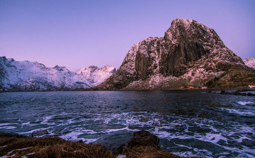 Scenic view of lake and mountains against clear blue sky
