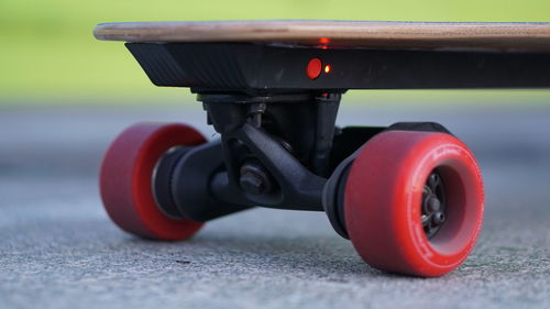 Close-up of red skateboard on road