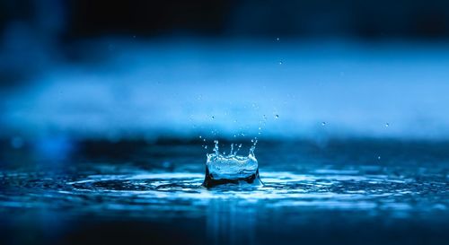 Close-up of water splashing against blue surface