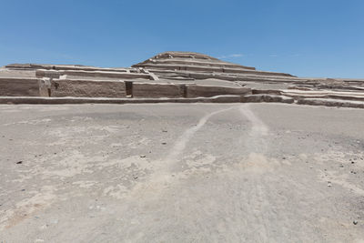 Stone wall in desert against sky