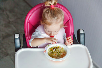 High angle view of cute girl sitting on table