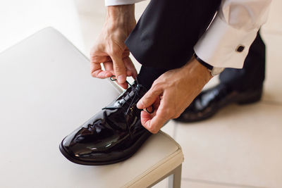 Low section of man tying shoelace