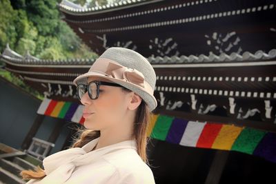 Close-up of young woman standing outside temple