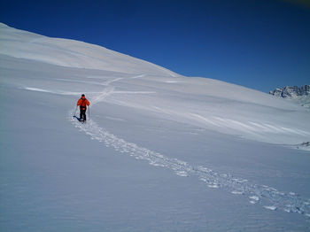 People skiing on snowcapped mountain against sky