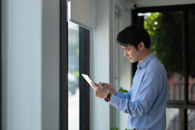 Side view of young woman using mobile phone