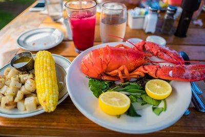 High angle view of lobster and corn with potatoes on table
