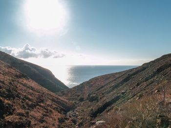 Scenic view of sea and mountains against sky