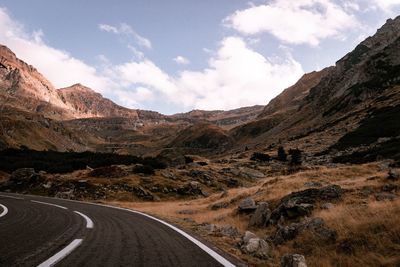 Road leading towards mountains against sky