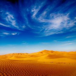 Scenic view of desert against blue sky