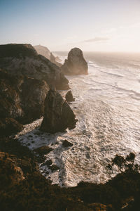 Rock formations by sea against sky