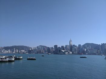 View of boats in sea against buildings in city
