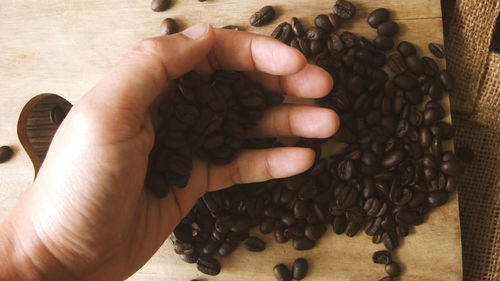 High angle view of hand holding coffee beans