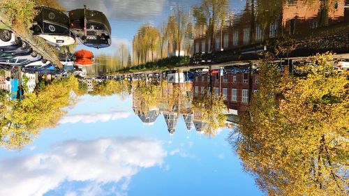 Reflection of buildings in lake against sky in city