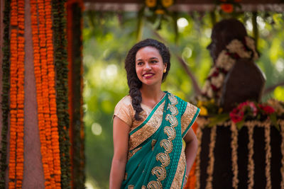 Smiling young woman standing at monument