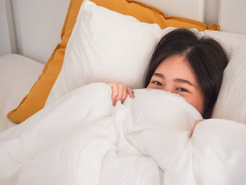 Portrait of woman relaxing on bed at home