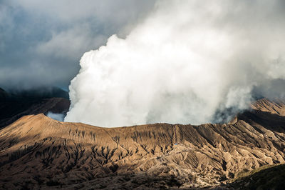 Smoke emitting from volcanic mountain against sky