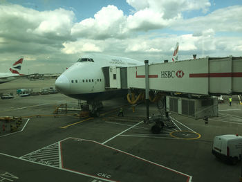 Airplane on airport runway against sky