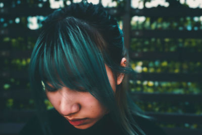 Close-up of young woman with bangs looking down