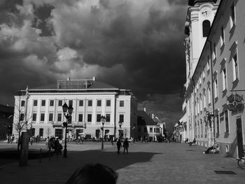 Buildings in city against cloudy sky