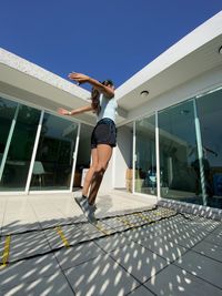 Mature woman exercising in front of house