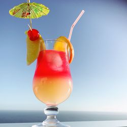 Close-up of drink in glass against blue sky