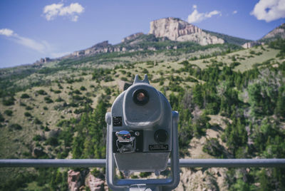 Close-up of coin-operated binoculars against mountain