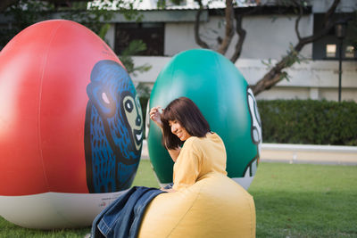 Portrait of young woman with balloons in park