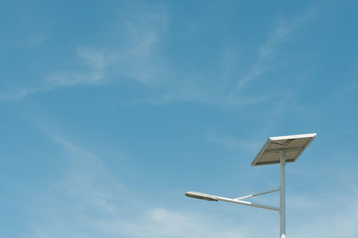 Low angle view of sunshade against blue sky