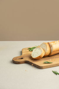 Sliced baguette with herbs on a beige background